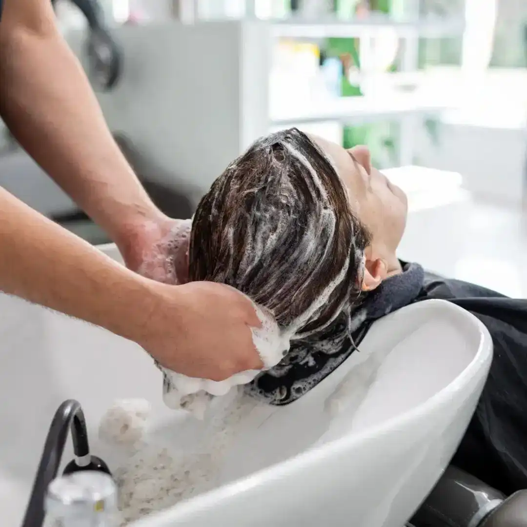 Hair being professionally washed at a salon sink.